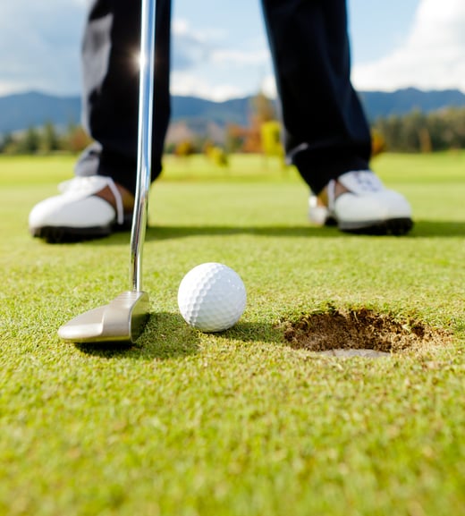 Golf player hitting the ball close-up on whole